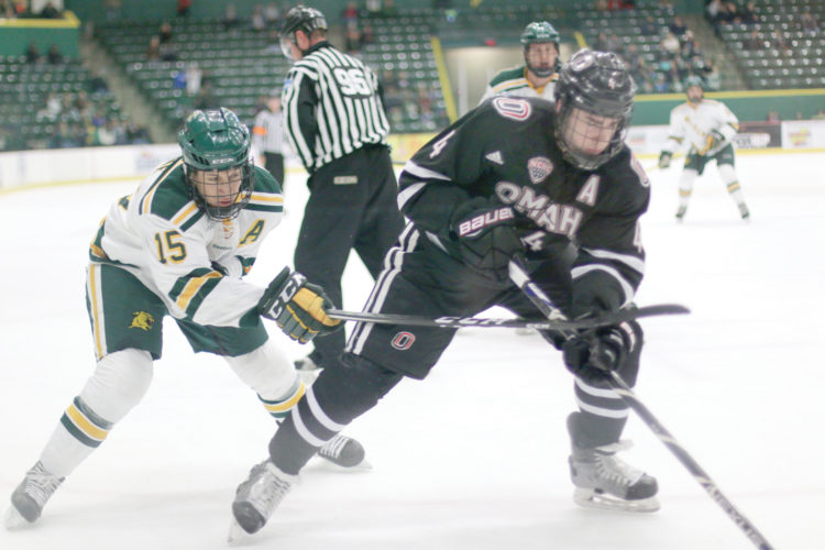 Northern Michigan University's Dominik Shine crosses sticks with University of Nebraska Omaha's Luc Snuggard Saturday night, Nov. 26, 2016, at the Berry Events Center in Marquette. (Journal photo by Rachel Oakley)